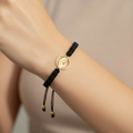 Mother Rosary Bracelet worn on wrist – gold praying mother charm on black macramé cord
