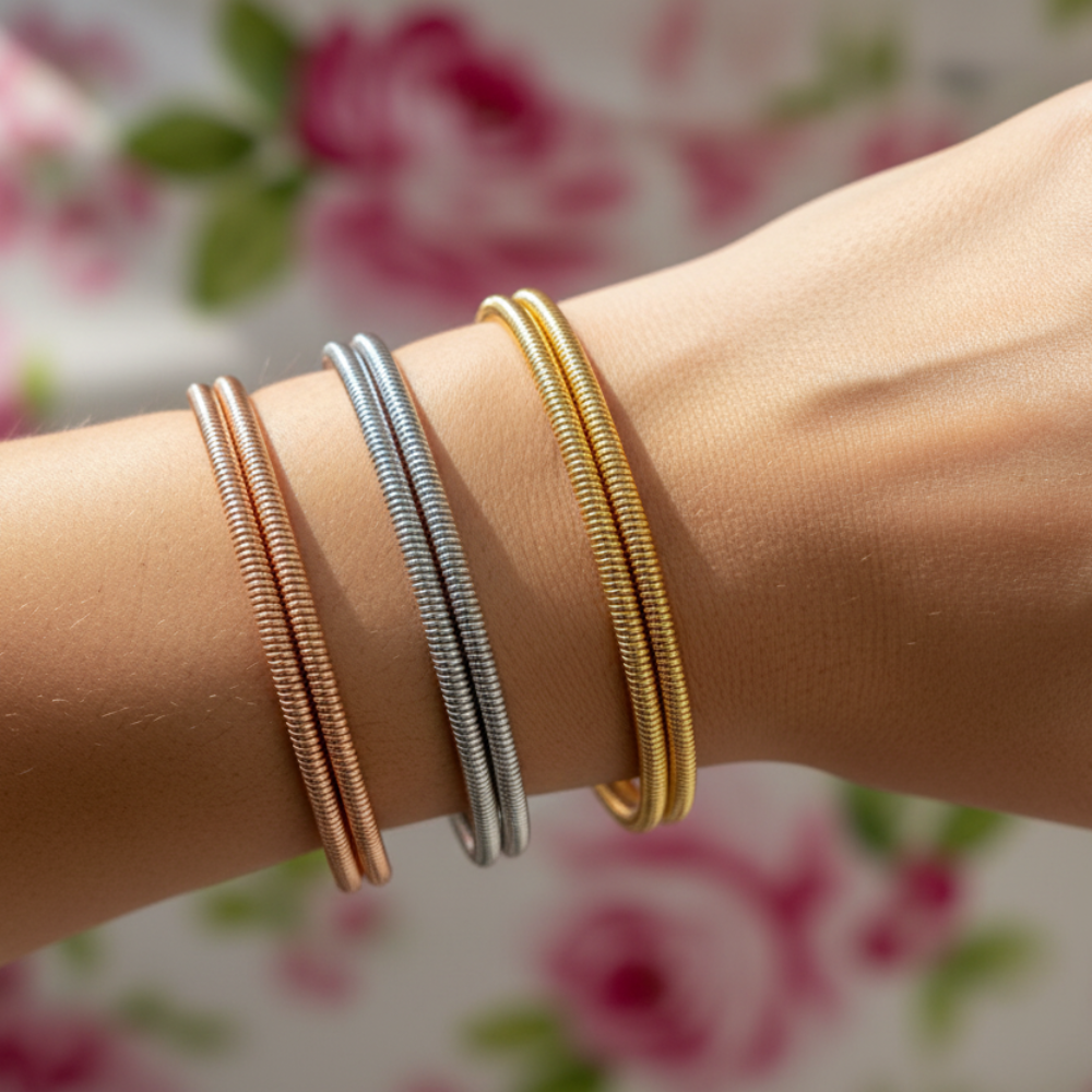 Stainless steel spring cuff bangles in gold, silver, and rose gold on wrist