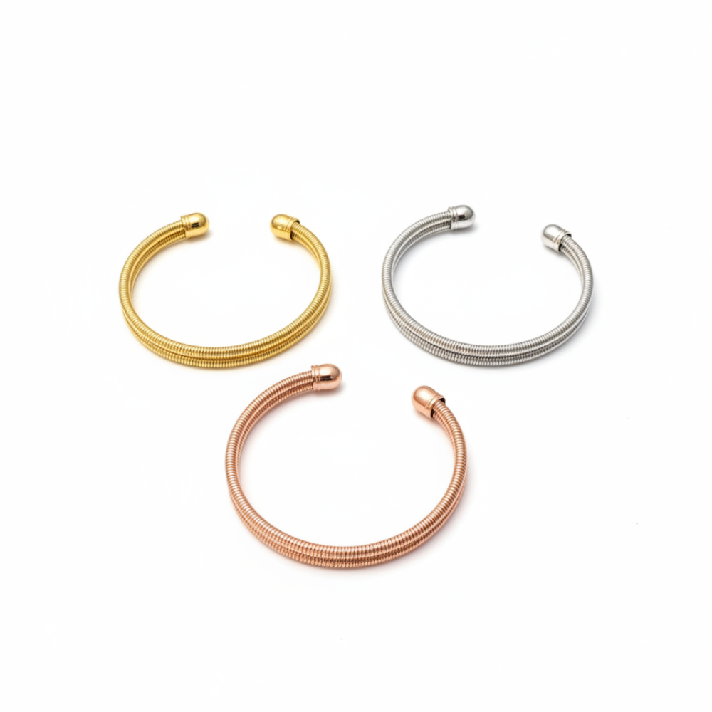 Stainless steel spring cuff bangles in gold, silver, and rose gold on wrist
