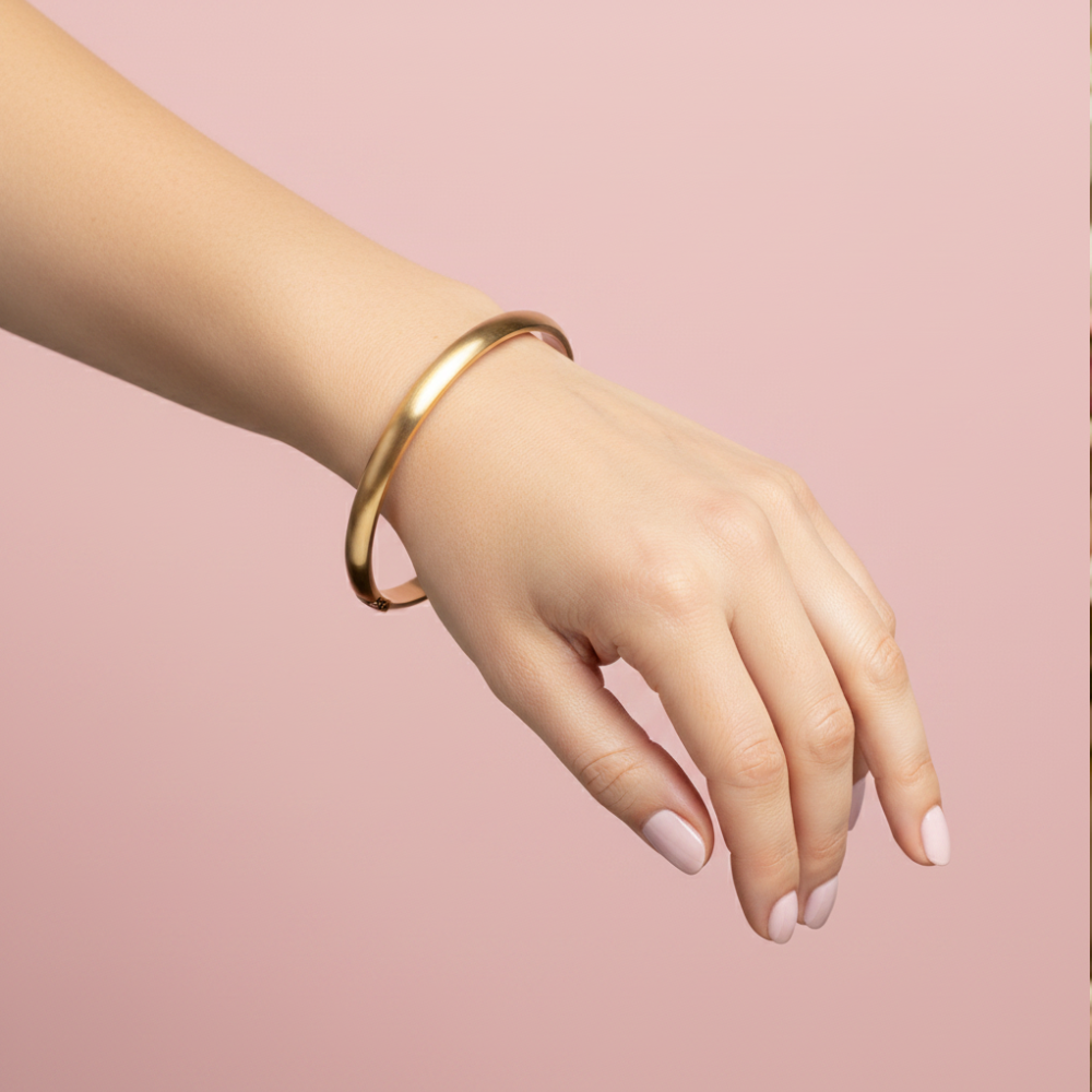 Gold bangle bracelet worn on woman's wrist