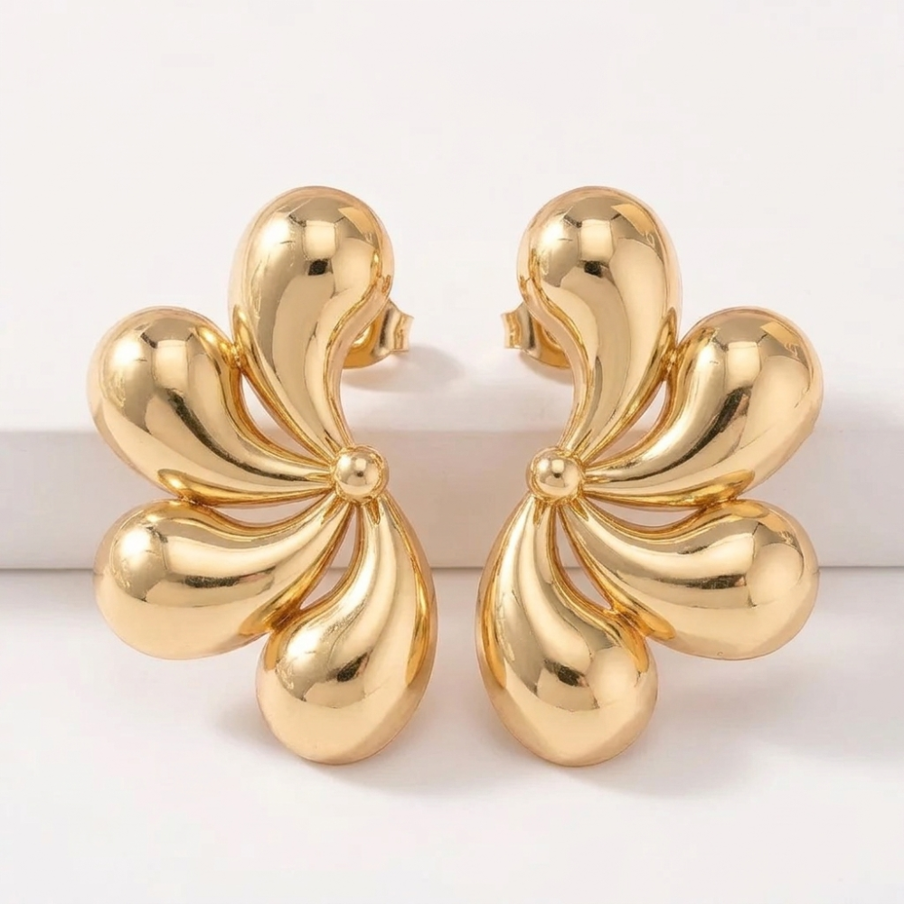 Gold flower statement earrings pair on white background
