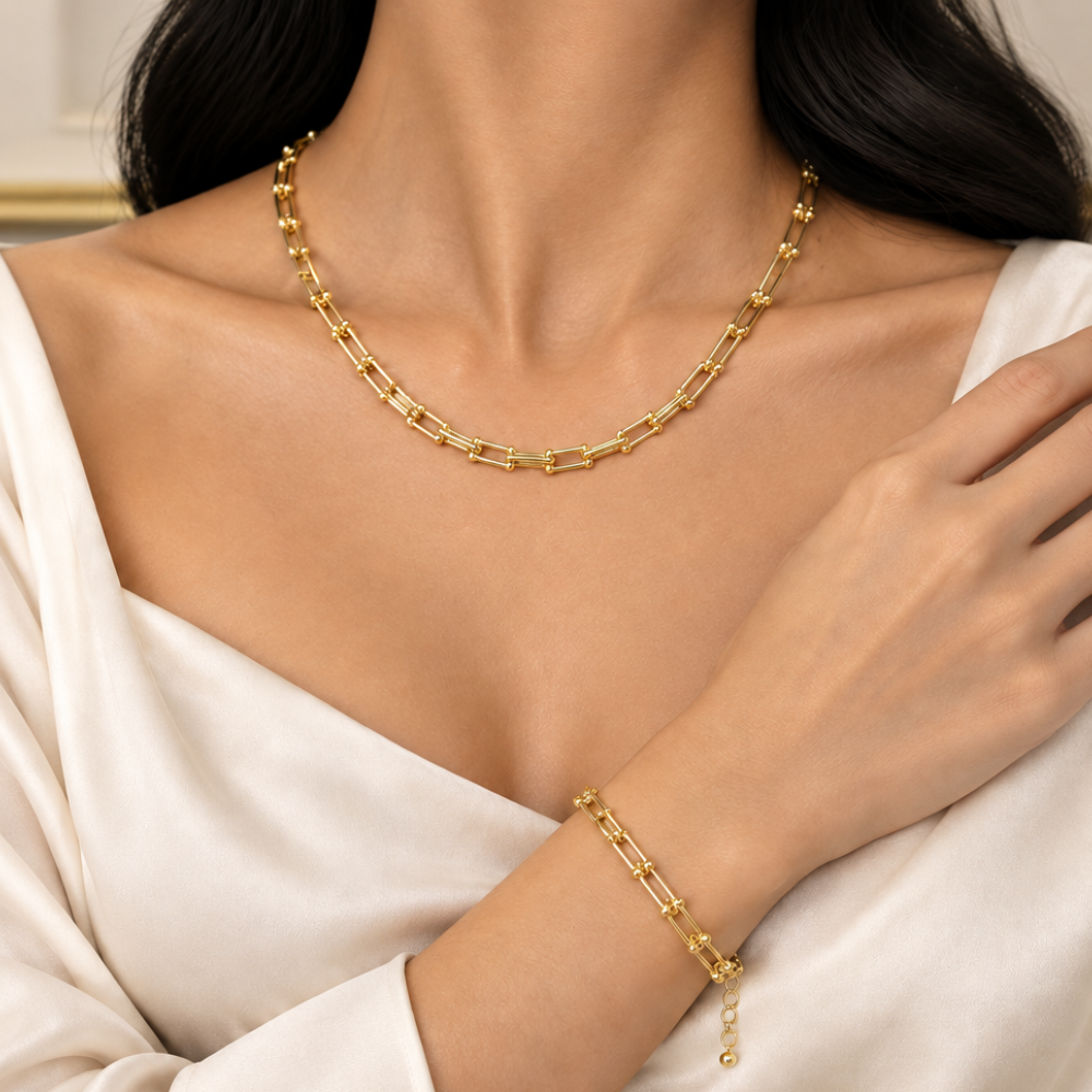Gold-plated stainless steel necklace and bracelet set on a white background