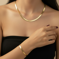Gold-plated stainless steel herringbone necklace and bracelet set on white background