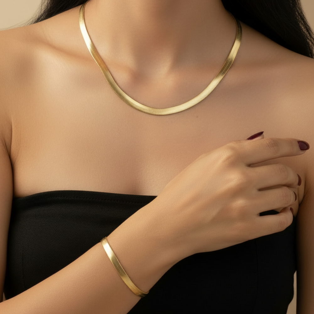 Gold-plated stainless steel herringbone necklace and bracelet set on white background