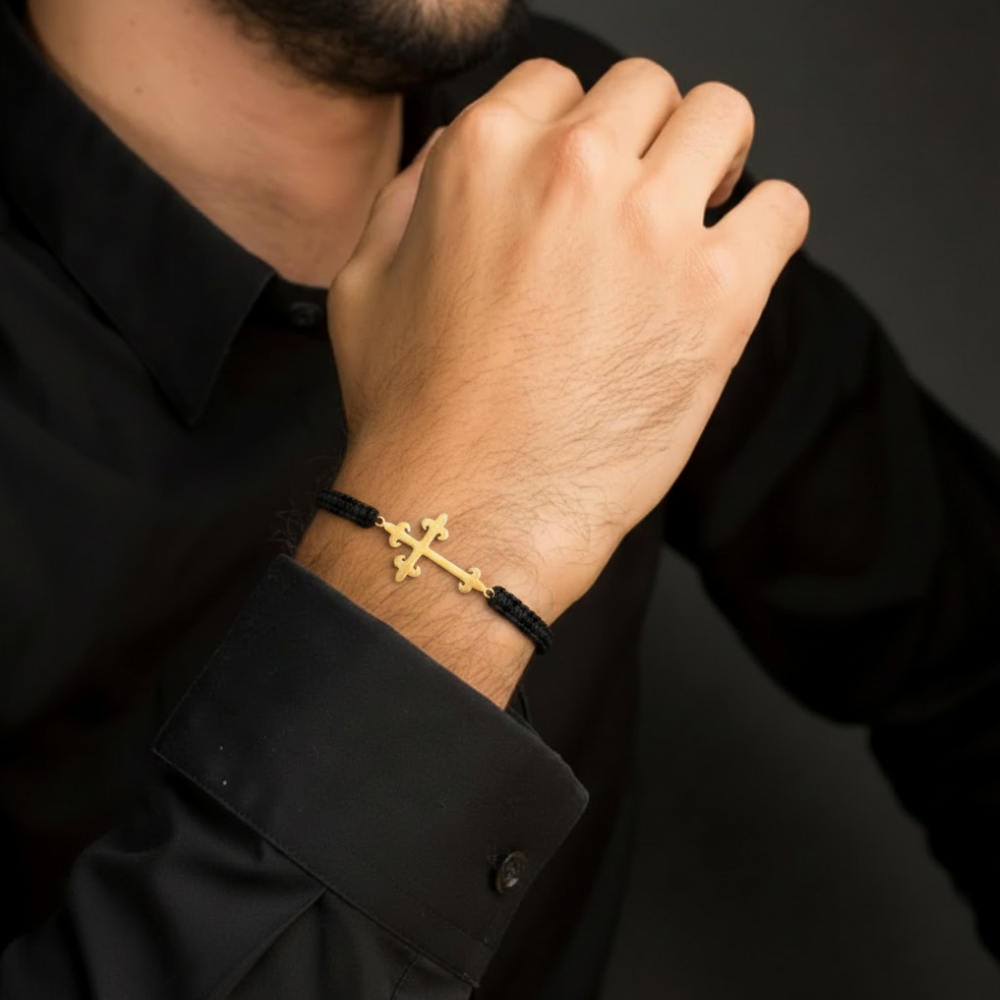 Man wearing gold cross bracelet on black macramé cord