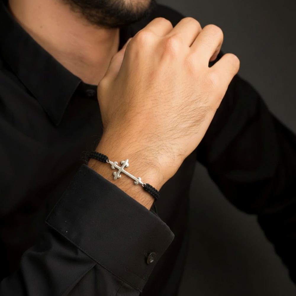 Man wearing silver cross bracelet on black macramé cord